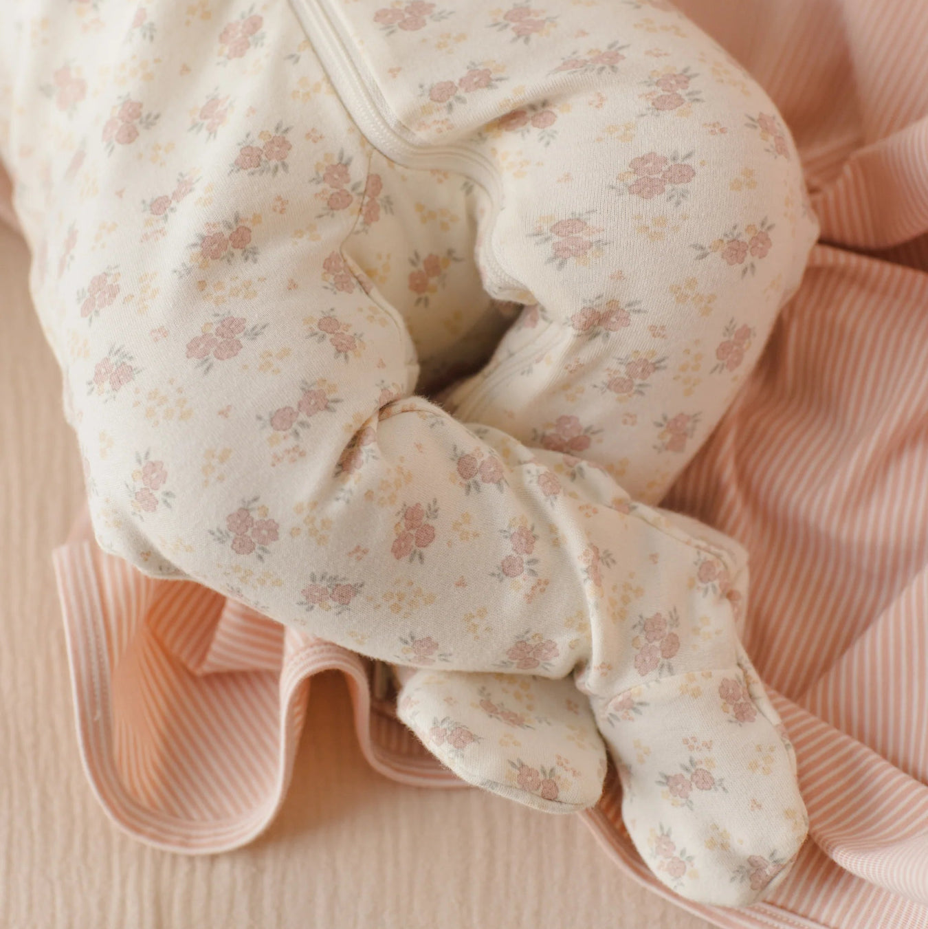 Floral-patterned baby outfit on a pink background