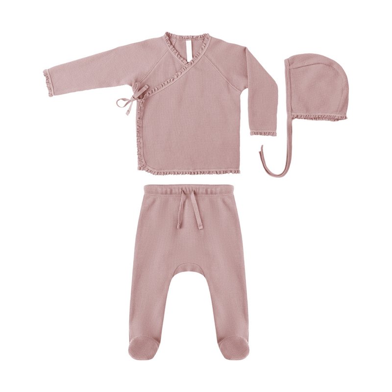Pink baby outfit with top, pants, and hat on a white background
