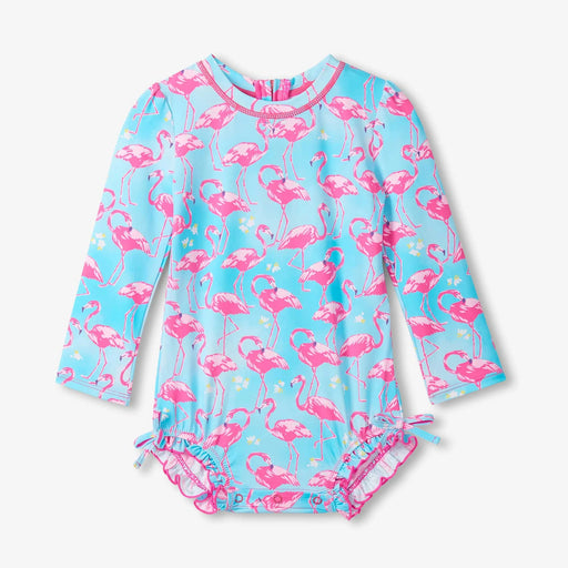 Children's swimsuit with pink flamingo pattern on a light blue background