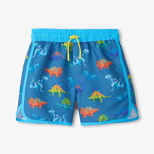Blue swim shorts with colorful dinosaur pattern on a light gray background