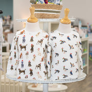 Baby clothes with dog pattern displayed on a rack in a store setting.