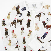 Close-up of Saltwater Swaddles Santa Dogs bamboo zipper footie with festive dogs in holiday scarves and Santa hats printed on soft white fabric