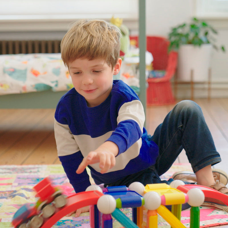 Boy racing SmartMax magnetic stunt cars on ramps