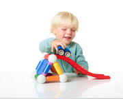 Child playing with a SmartMax magnetic stunt car on a red ramp