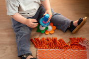 Toddler building with SmartMax My First Sounds & Flowers on a rug