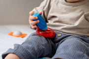 Toddler shaking a SmartMax My First Sounds & Flowers rattle piece