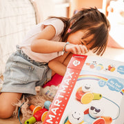 Girl opening a SmartMax My First Wobbly Cars box