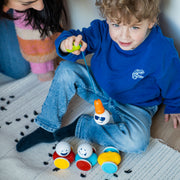 Child building with SmartMax My First Wobbly Cars on a rug