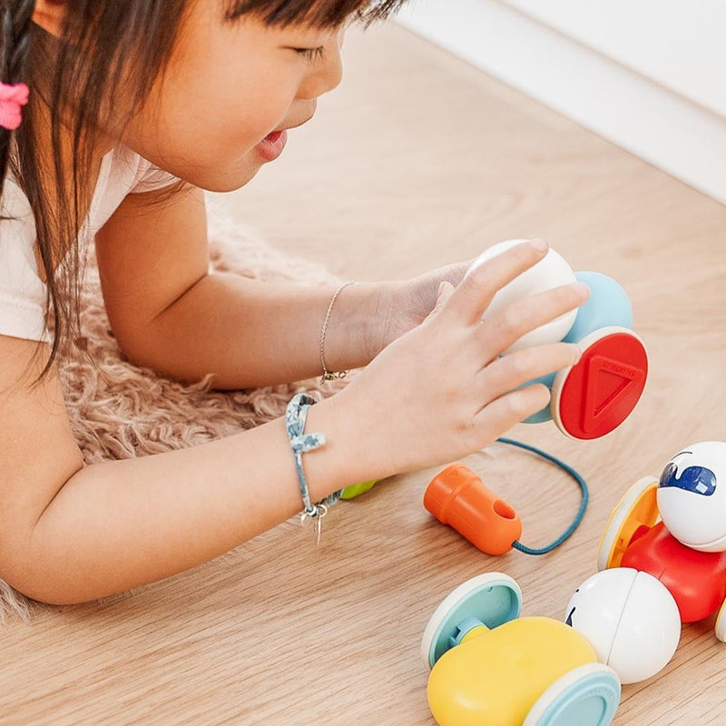 Toddler pulling SmartMax My First Wobbly Cars across the floor