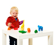 Child playing with colorful toy animals on a white table