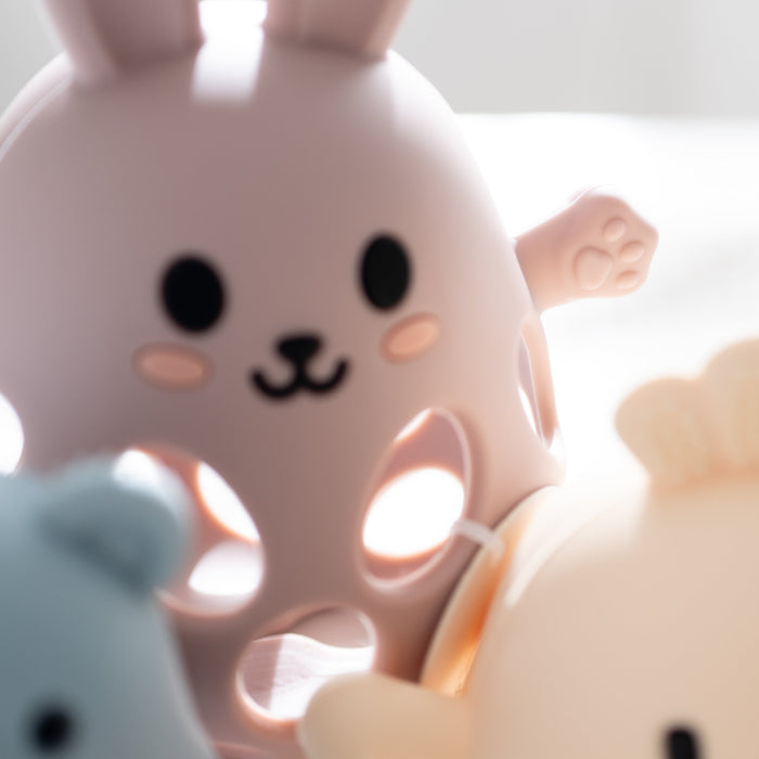 Two cute animal-shaped objects, one pink and one beige, on a light background.