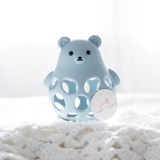 Blue bear-shaped teether on a white surface