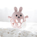 Pink rabbit-shaped teether on a white textured surface