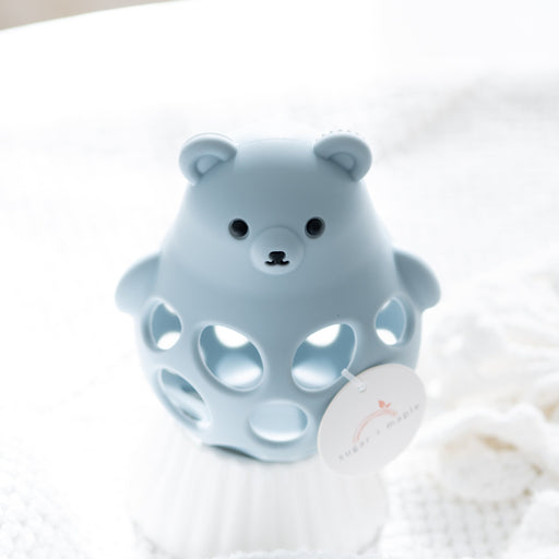 Blue bear-shaped bath toy on a white fluffy surface