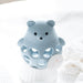 Blue bear-shaped bath toy on a white fluffy surface