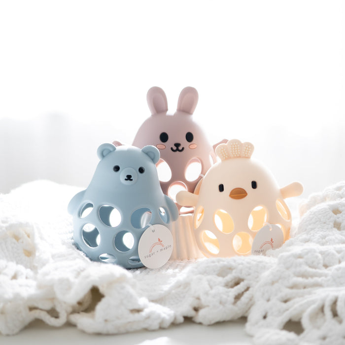 Three colorful animal-shaped toys on a textured white surface