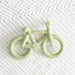 Light green bicycle-shaped teether on a white textured background
