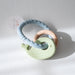 Baby teether with green whale and wooden ring  on a white background
