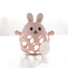 Pink rabbit-shaped teether on a white surface with a blurred background