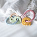 two colorful baby teething rings on a textured white surface