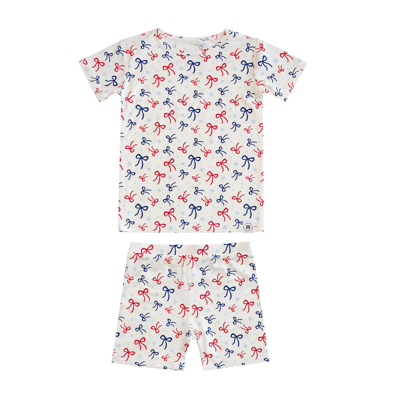 Children's pajama set with bow pattern on a white background