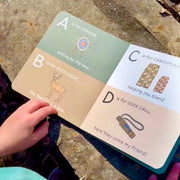 Children's alphabet book open on a stone surface