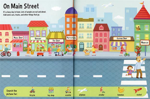Interior spread showing a busy town street scene with shops, cars, bikes, and people. Sections along the bottom prompt children to find various items.
