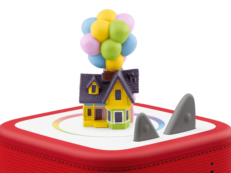 Toy house with balloons on a red base with shark fins, against a transparent background