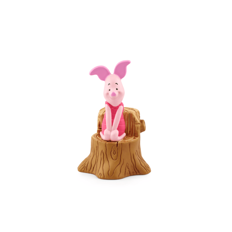 Pink piglet figurine sitting on a wooden stump against a white background