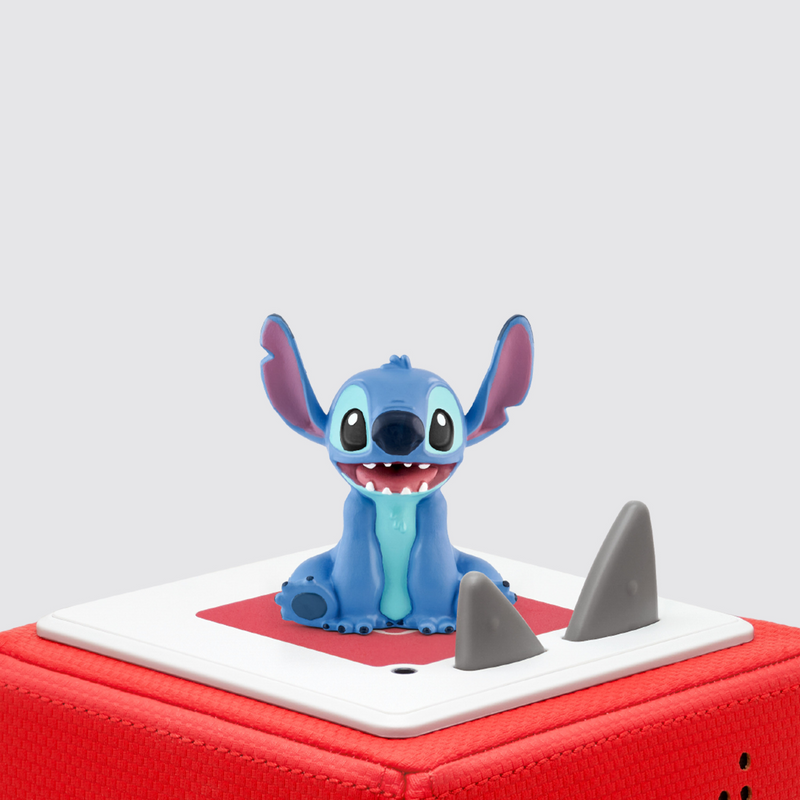 Blue cartoon character figurine on a red and white base with shark fins.