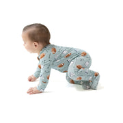 Baby in a crawling position wearing the football-print romper on a clean white background.