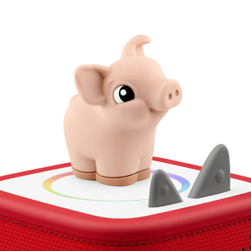 Toy pig on top of a red tonies box  on a white background