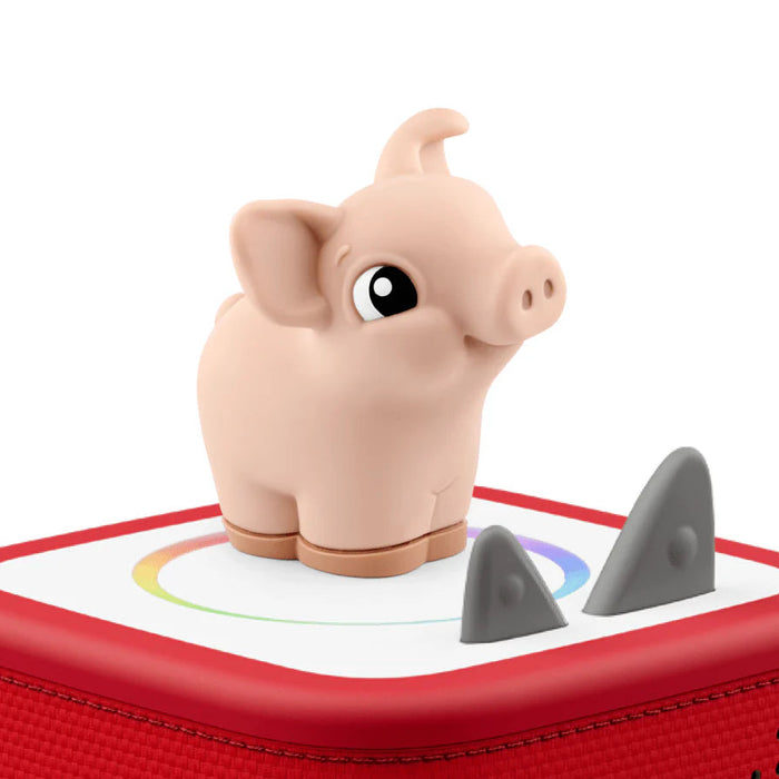 Toy pig on top of a red tonies box  on a white background