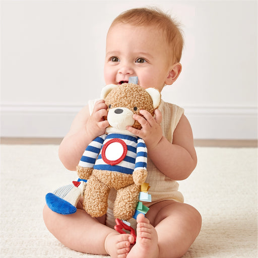 Baby sitting and playing with the Bitzy Traveler sensory toy during floor play