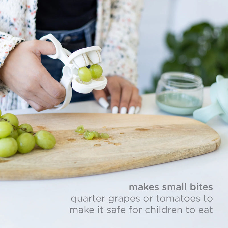 Lifestyle: cutter quartering grapes on a board with “makes small bites” text.