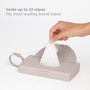 Hand pulling a wipe from the Ubbi On-the-Go Wipes Dispenser, which holds up to 22 wipes