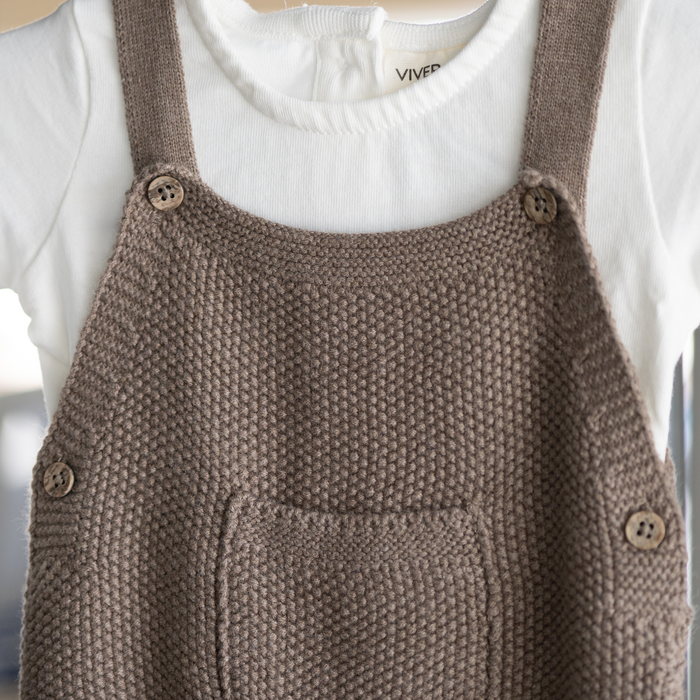 Brown knitted overall with buttons on a white background