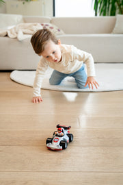 Baby crawling after WOW Toys Richie Race Car