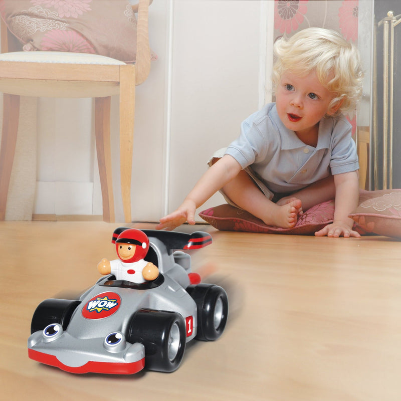 Toddler pushing WOW Toys Richie Race Car across the floor