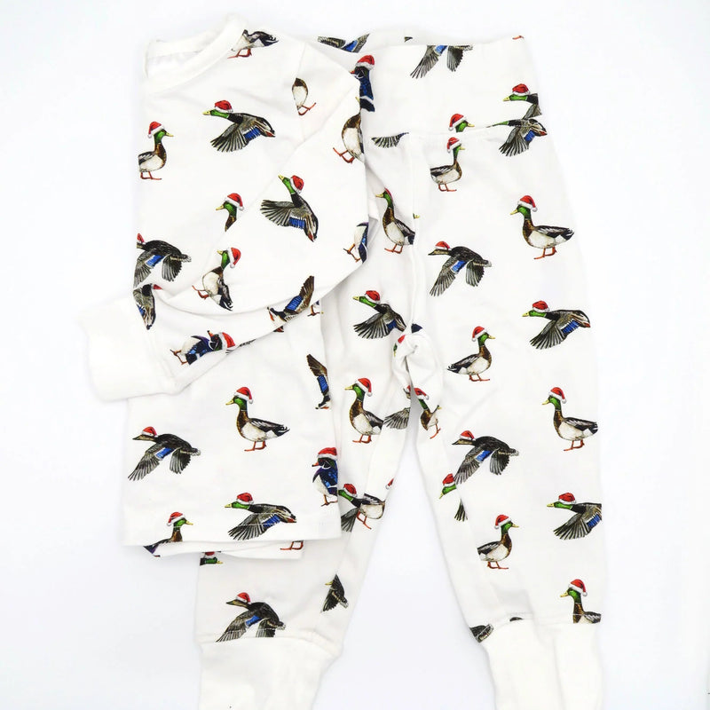 Flatlay of Saltwater Swaddles Duck the Halls kids pajamas with watercolor ducks wearing Santa hats on white background