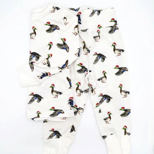 Flatlay of Saltwater Swaddles Duck the Halls kids pajamas with watercolor ducks wearing Santa hats on white background