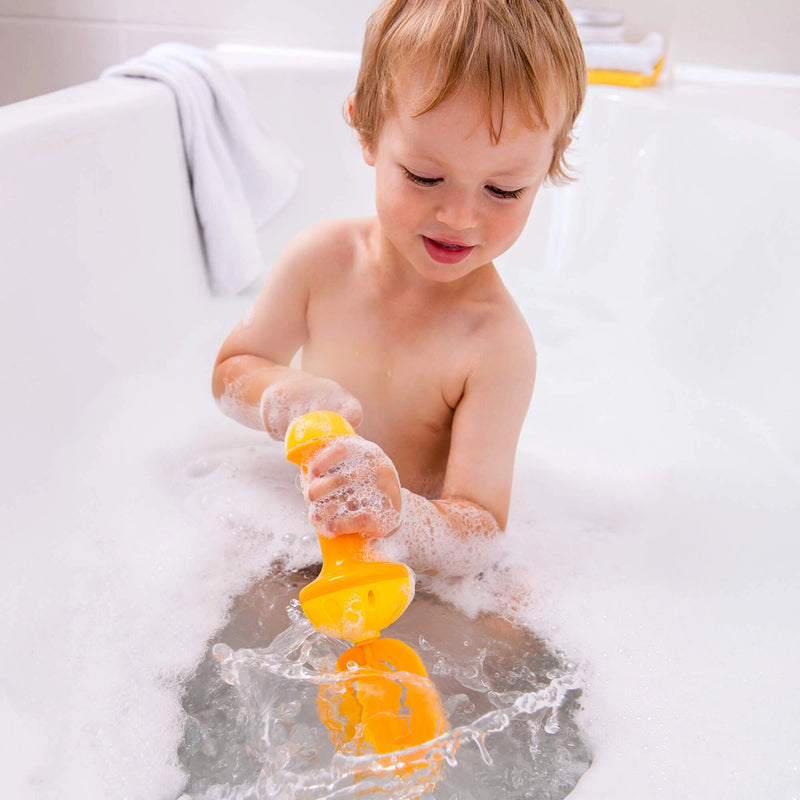 Child playing with a yellow bath toy in a bathtub filled with bubbles